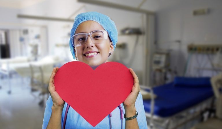 A nurse holding a heart-shaped paper.