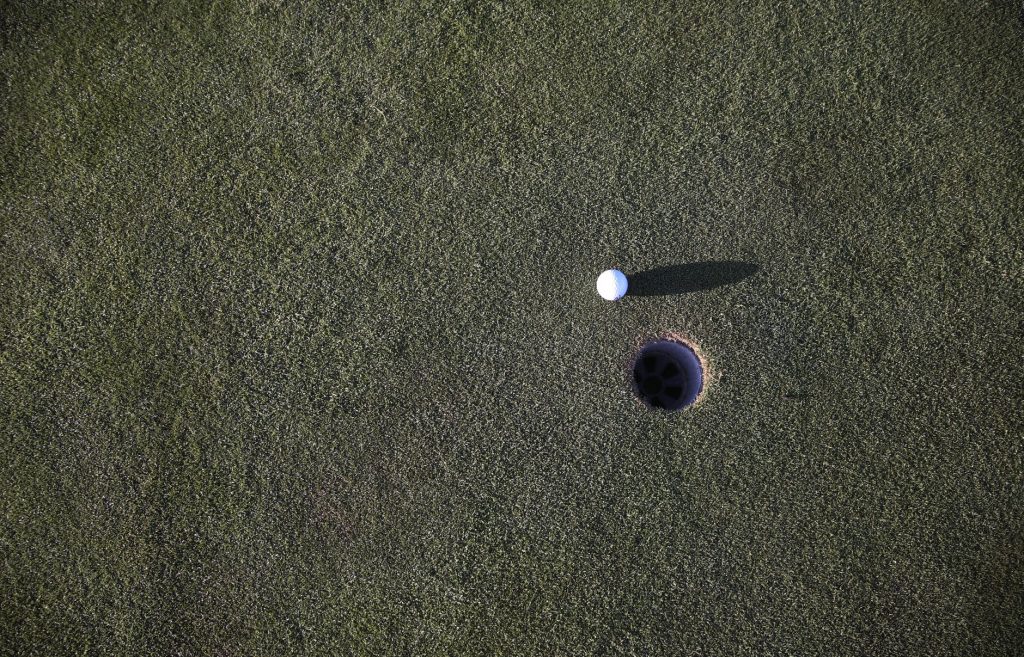 golf ball next to a golf hole