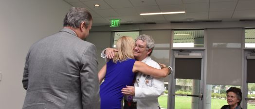 A woman and man hugging to celebrate a gift given.