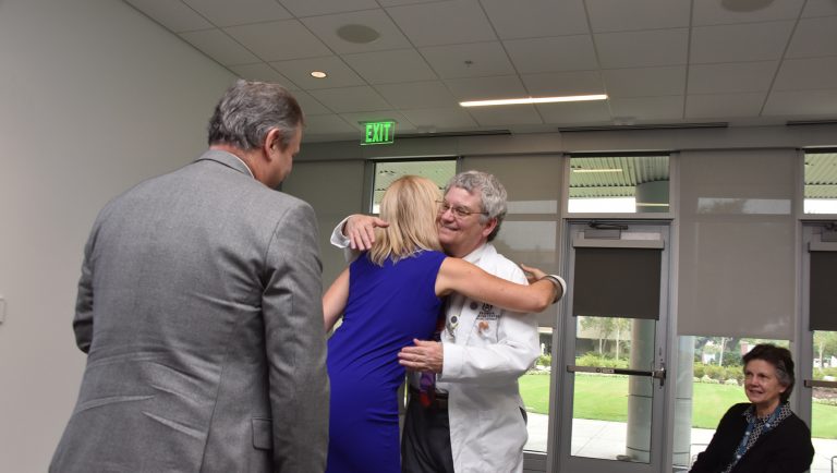 A woman and man hugging to celebrate a gift given.
