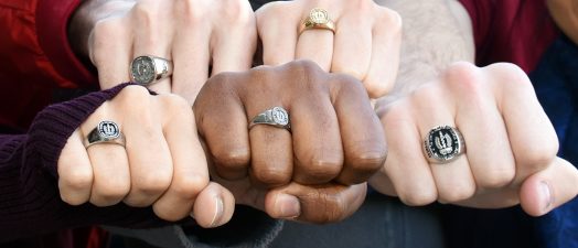 Five fists showing class rings