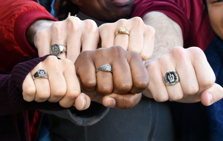 Five fists showing class rings