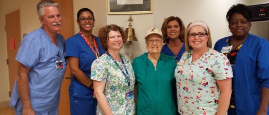 A woman surrounded by nursing staff at the Georgia Cancer Center