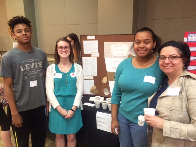 students smiling in front of poster presentation