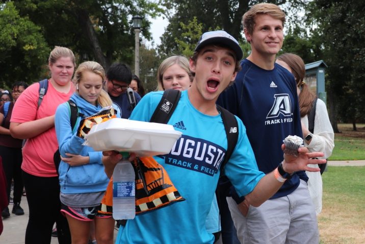Student makes excited face with to-go plate