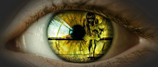 up close view of an eye looking and seeing a girl sitting down