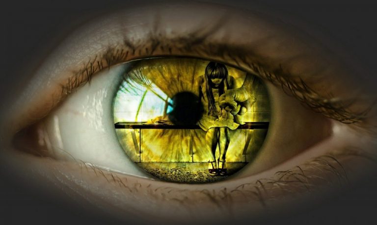 up close view of an eye looking and seeing a girl sitting down