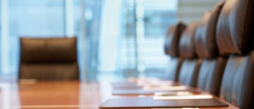 Closeup of a boardroom table and six chairs