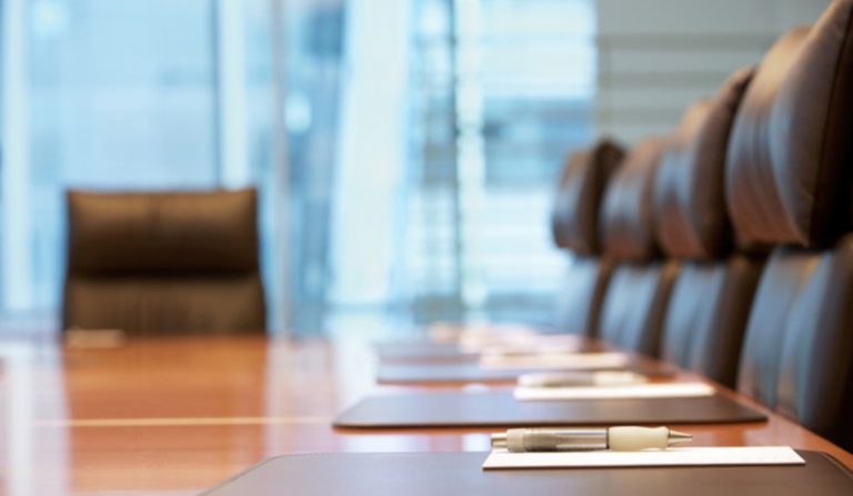 Closeup of a boardroom table and six chairs