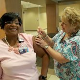 Nurse giving woman a flu shot.