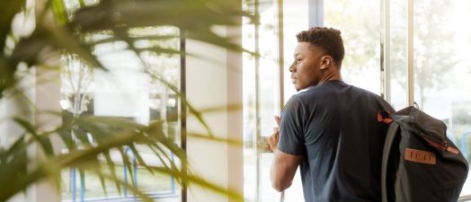 student walking through a door
