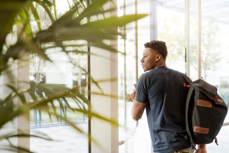 student walking through a door