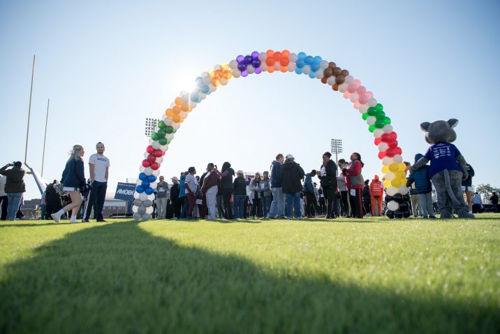 A photo of people standing under a balloon arch.
