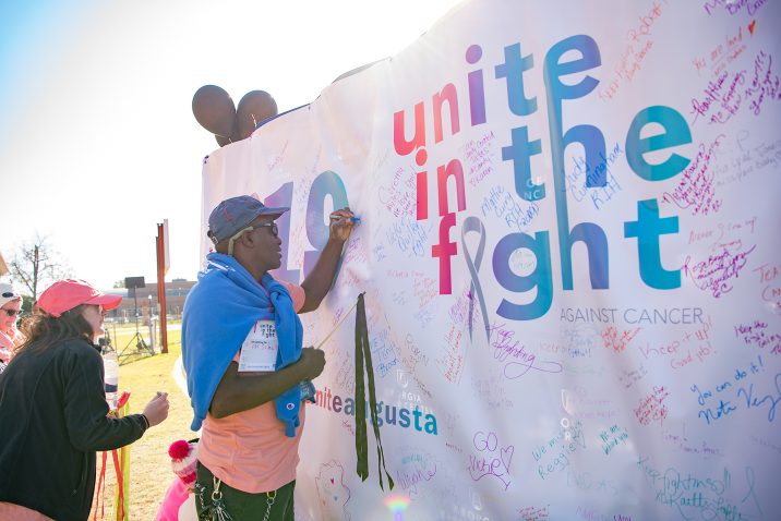 People signing a sign to let others know why they took part in the walk.