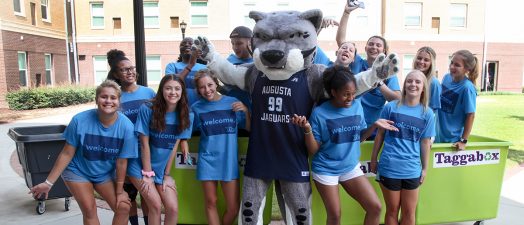 students smiling with the school mascot