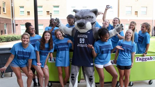 students smiling with the school mascot