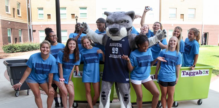 students smiling with the school mascot