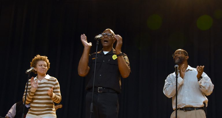 three people singing on stage