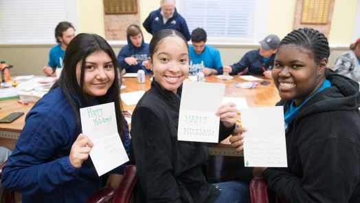 students smiling with handmade holiday cards