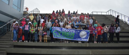 people standing outside holding a sign