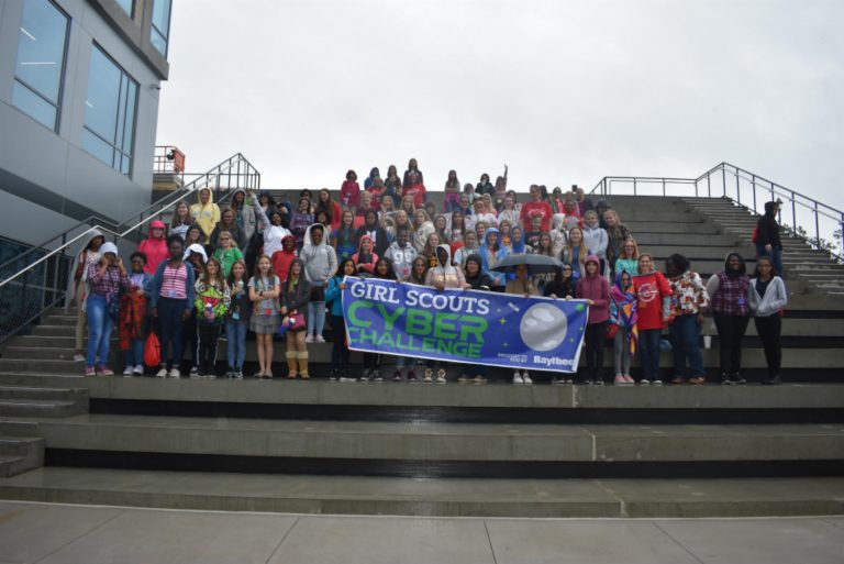people standing outside holding a sign