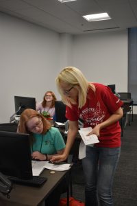 adult helping with assignment at desk