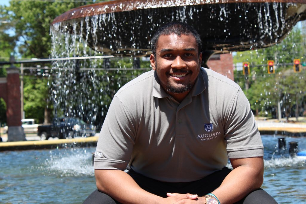 Man sitting in front of a fountain