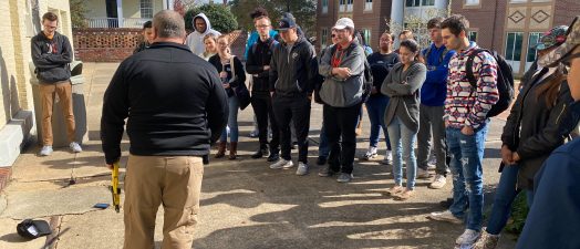 man teaching students outside