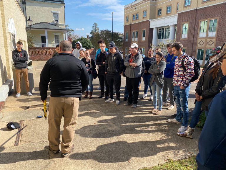 man teaching students outside