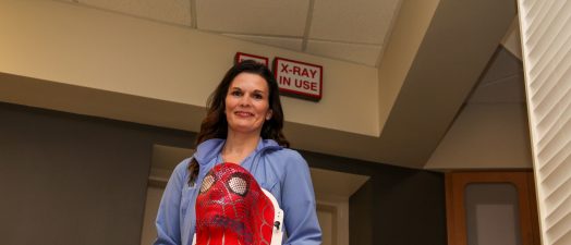 Woman holding a Spider-man mask used for radiation treatment