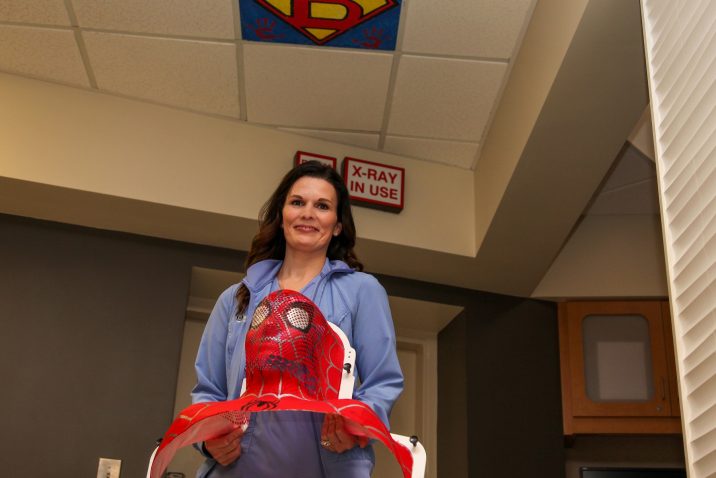 Woman holding a Spider-man mask used for radiation treatment
