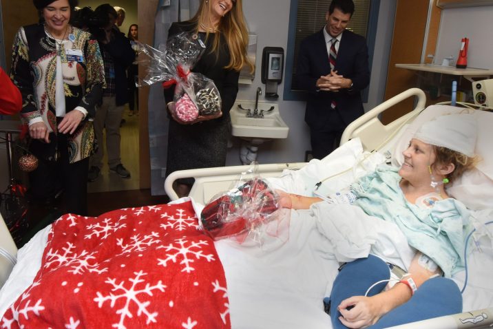 woman greeting patient in hospital bed