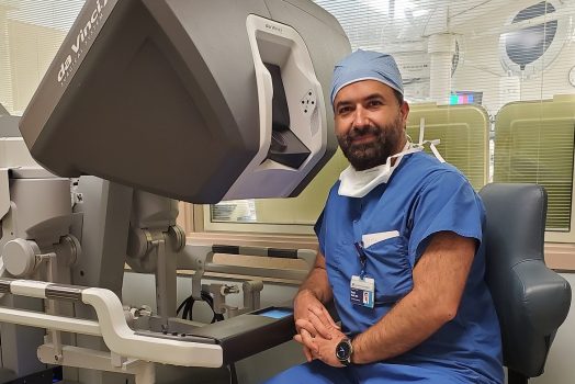 A doctor sitting at a console where doctors perform robotic surgeries.