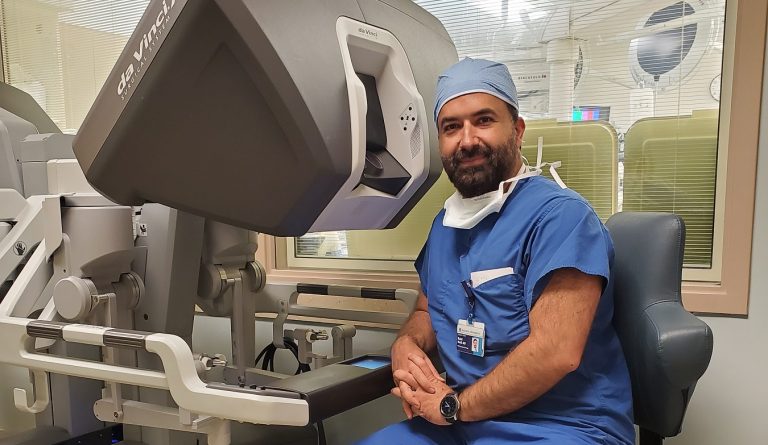 A doctor sitting at a console where doctors perform robotic surgeries.