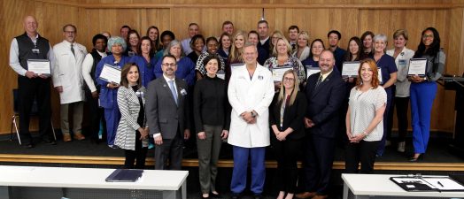 A group of people standing with certificates.