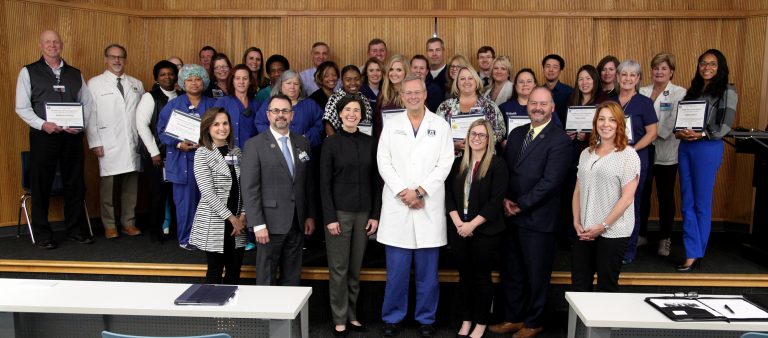 A group of people standing with certificates.