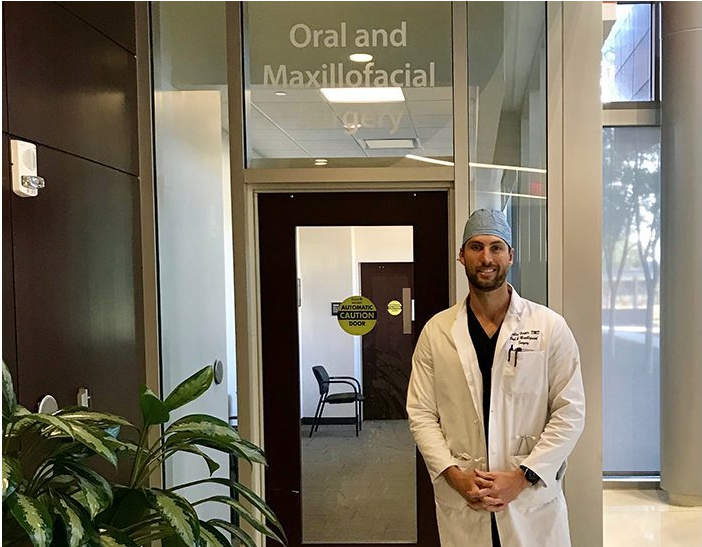 man standing in front of a dental office