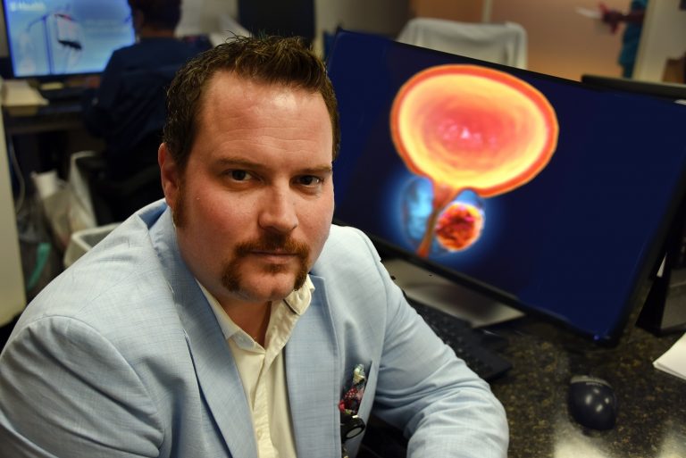 man sitting next to computer