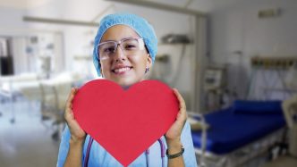 A nurse holding a heart-shaped paper.