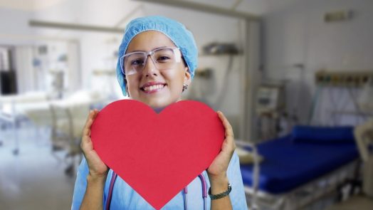 A nurse holding a heart-shaped paper.
