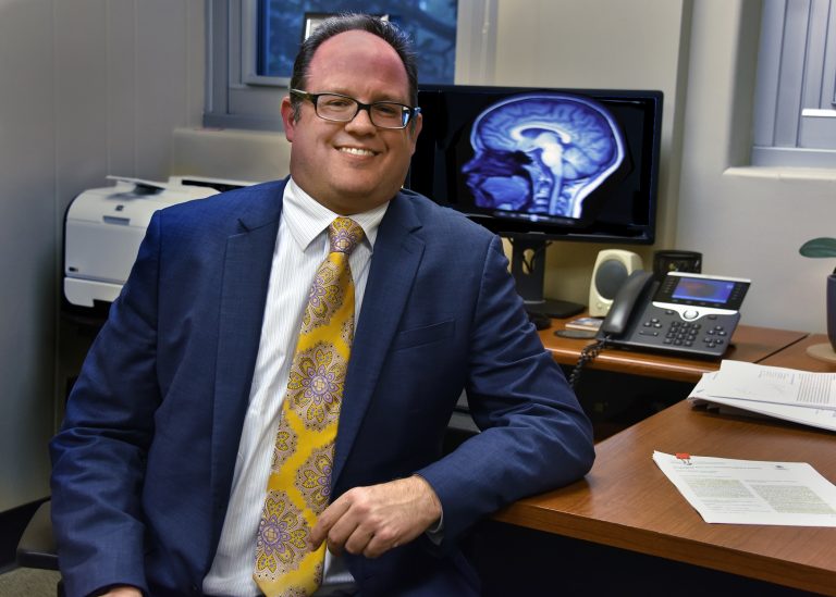man in suit smiling at desk