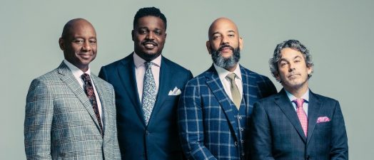 people standing in suits and smiling