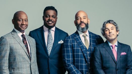 people standing in suits and smiling