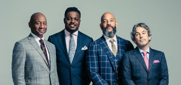 people standing in suits and smiling