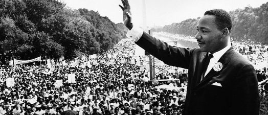 black and white photo of a man waving to a crowd full of people