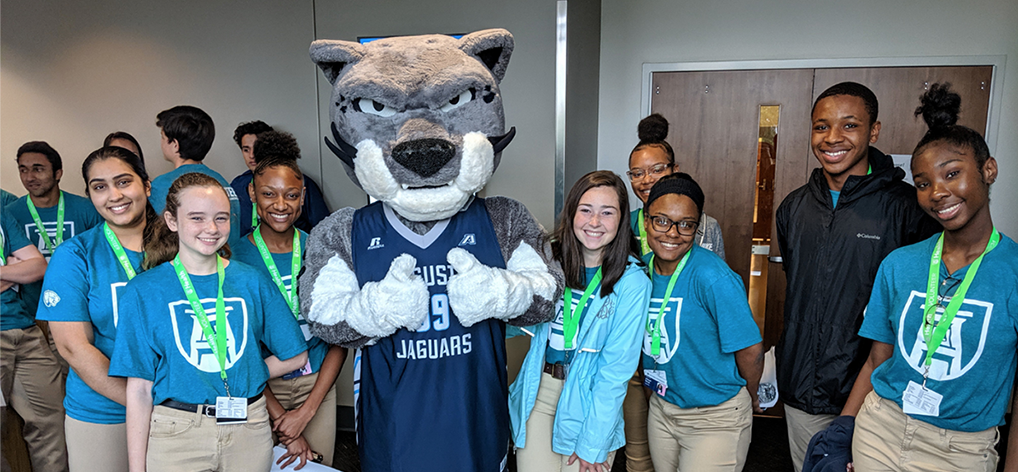 Students smiling with the university mascot