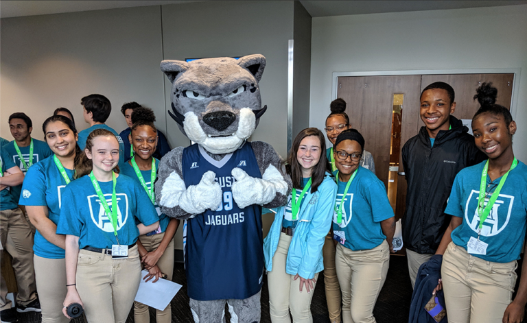 Students smiling with the university mascot