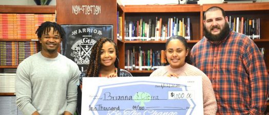 people smiling holding a check