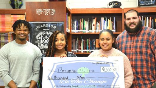 people smiling holding a check