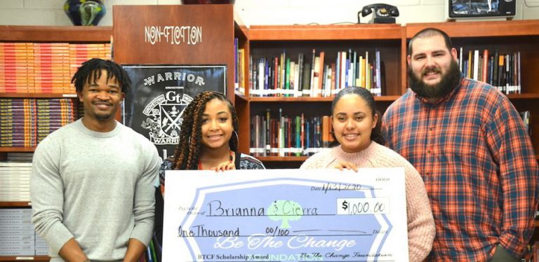 people smiling holding a check